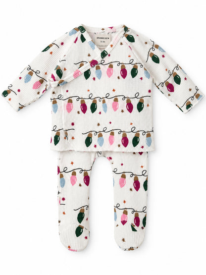 White infant outfit featuring colorful holiday lights pattern, consisting of a long-sleeve top and leggings.