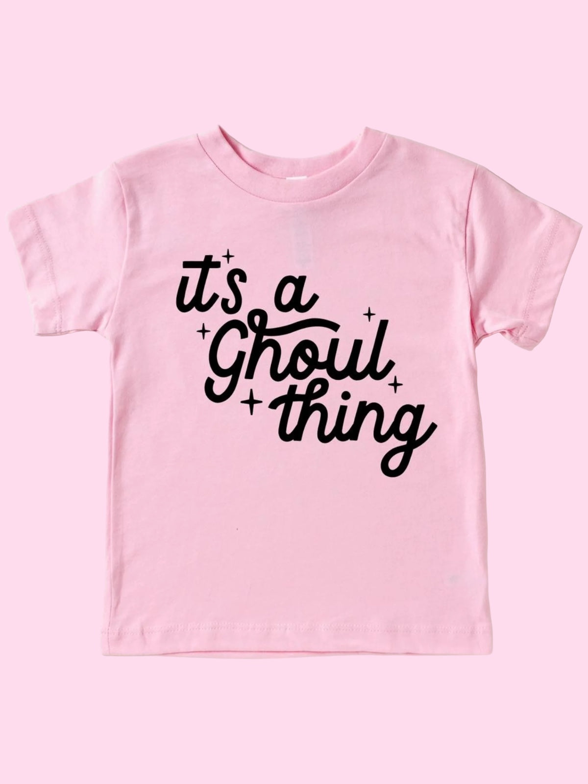Pink t-shirt with the text "it's a Ghoul thing" in black lettering and playful star accents.