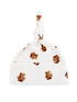 White baby hat with a knot at the top, featuring a teddy bear print and delicate, textured design.