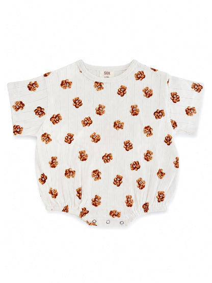 White baby romper with a playful bear print pattern, featuring short sleeves and snap closures.