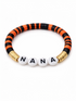 Colorful beaded bracelet featuring the word "NANA" in white letters on a black and orange striped band.