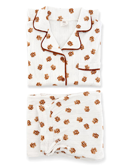 White pajama set featuring brown floral patterns, neatly folded with a top and bottom piece visible.