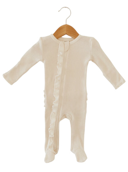 Cream-colored baby onesie with long sleeves and ruffle detail, displayed on a wooden hanger.