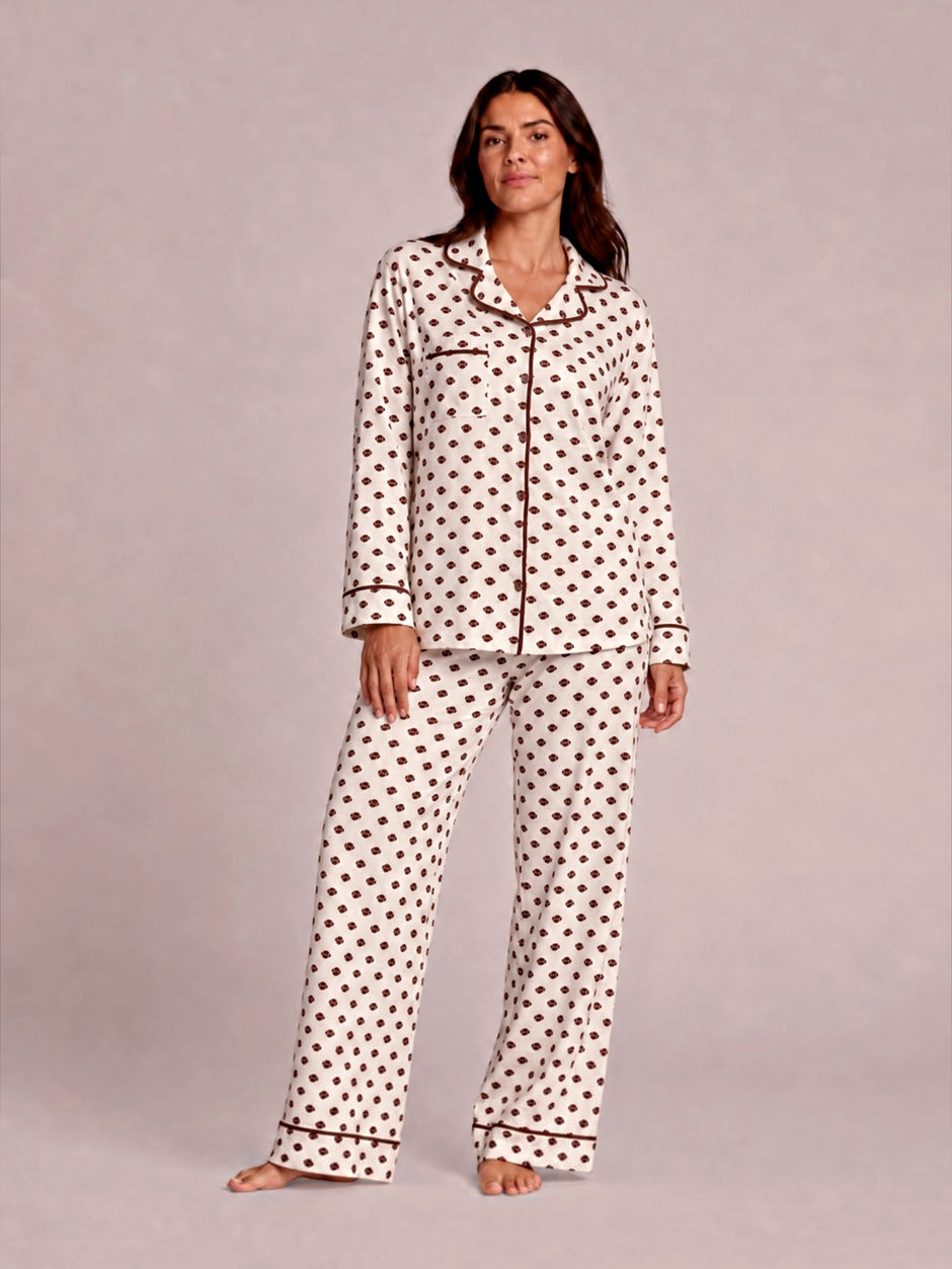 Woman in polka dot pajamas poses confidently against a light background. Casual, cozy sleepwear fashion.