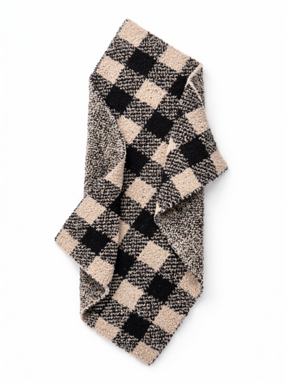 Checkered scarf in black and beige, folded on a white background. Ideal for winter fashion.