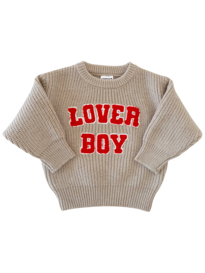 Beige sweater with red "LOVER BOY" text, featuring a cozy knit texture and oversized fit.