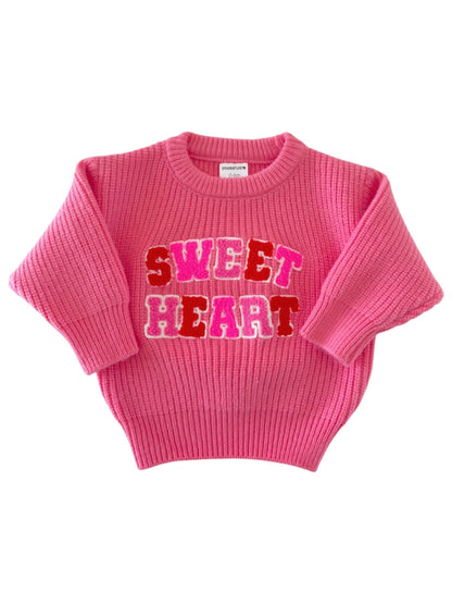 Pink sweater featuring "SWEET HEART" text in colorful letters on the front. Ideal for kids' fashion.