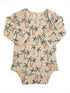 Beige baby bodysuit with palm tree print, featuring long sleeves and snap buttons at the bottom.