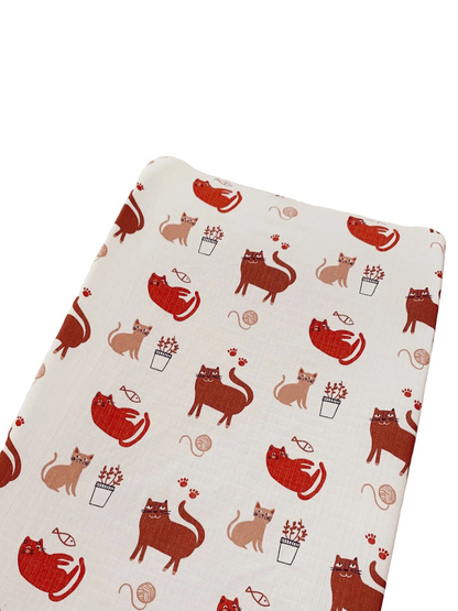 Patterned fabric featuring playful cats in various poses with plants and yarn.