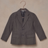 Gray children's blazer hanging on a rose gold hook against a textured background.