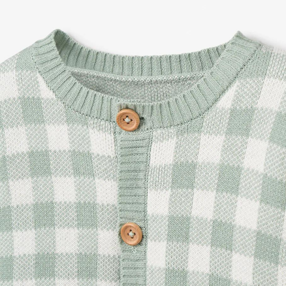 Green and white checkered sweater with a round neckline and wooden buttons.