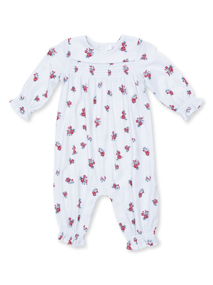 White floral baby romper with long sleeves and button closure, featuring small red rose patterns throughout.