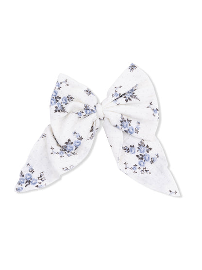 Floral patterned hair bow in white and blue fabric, tied in a large bow shape.