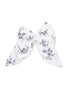 Floral patterned hair bow in white and blue fabric, tied in a large bow shape.