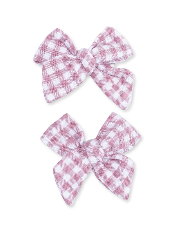 Two pink and white gingham hair bows laid side by side against a white background.