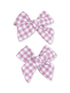 Two pink and white gingham hair bows laid side by side against a white background.