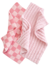 Two soft pink towels, one in a checkered pattern and the other with a ribbed texture, arranged together.