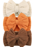 Three textured headbands in cream, orange, and brown, featuring large fabric bows on each band.