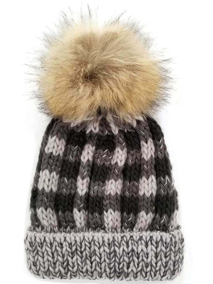 Knitted beanie hat with a fluffy pom-pom on top in gray and black colors.
