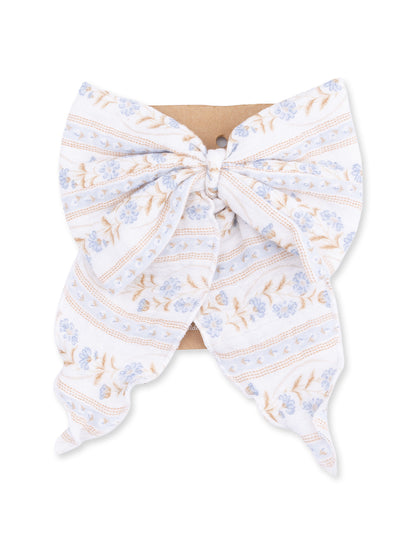Floral patterned hair bow in blue and white, displayed on a brown cardstock tag.