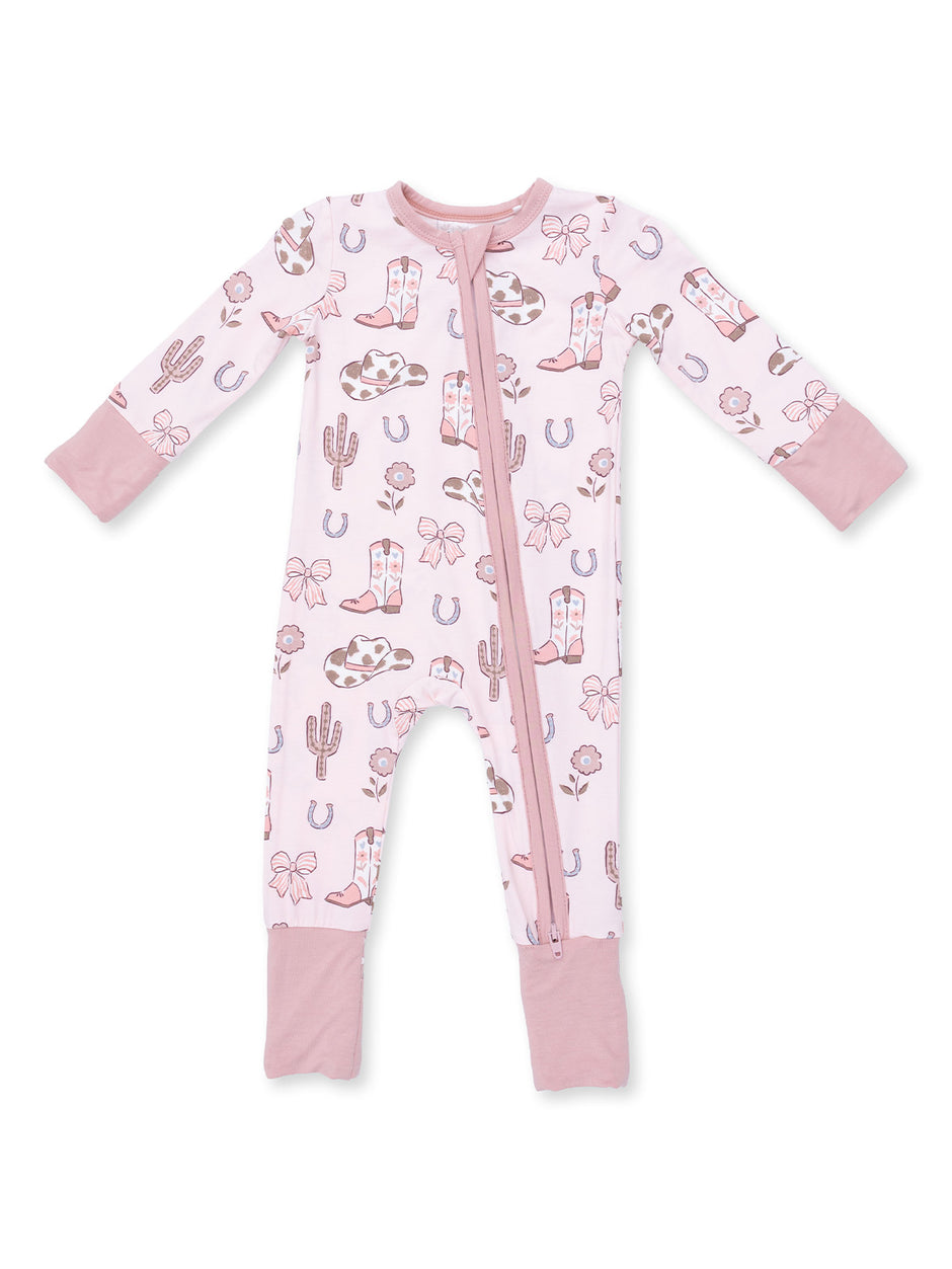 Pink infant pajamas with cowboy and cactus patterns, featuring long sleeves and a front zipper.