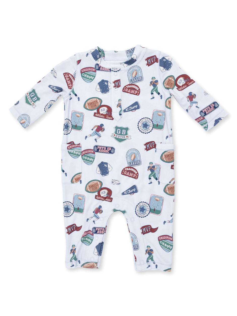 Infant onesie featuring a colorful sports-themed pattern with badges and illustrations of children playing sports.
