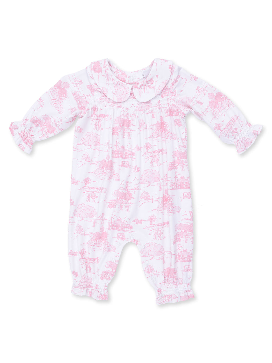 Pink baby romper with a collar featuring a whimsical pattern of trees and landscapes.