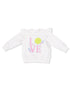 White toddler sweatshirt with ruffled sleeves, featuring "LOVE" and tennis graphics in colorful embroidery.