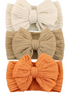 Three textured bows in cream, beige, and orange on headbands, ideal for stylish hair accessories.