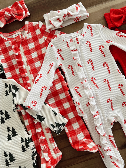 Christmas-themed infant outfits, featuring red plaid and candy cane patterns, with matching headbands and accessories.