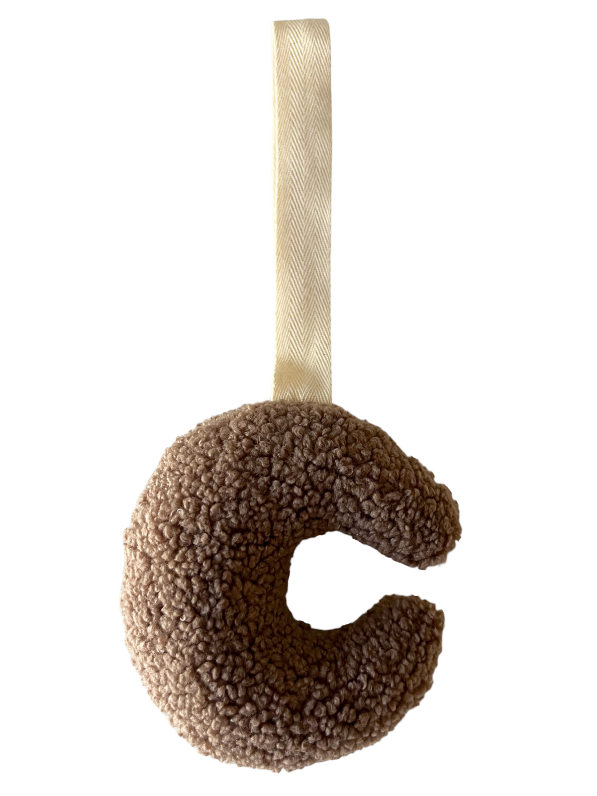Fluffy brown letter "C" shaped plush toy with a beige ribbon loop for hanging.