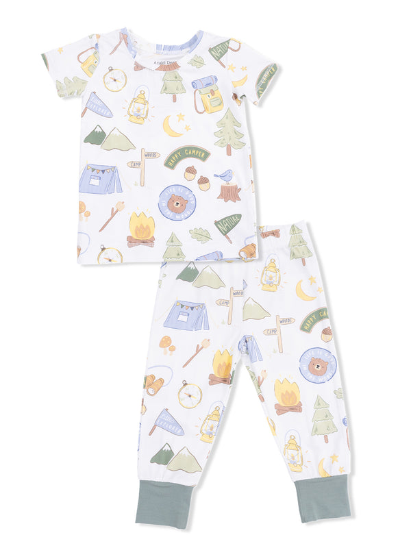 Kids' camping-themed pajamas featuring playful graphics of trees, tents, lanterns, and a bear.