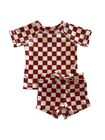 Red and white checkered kids' swim shirt and shorts set on a white background.