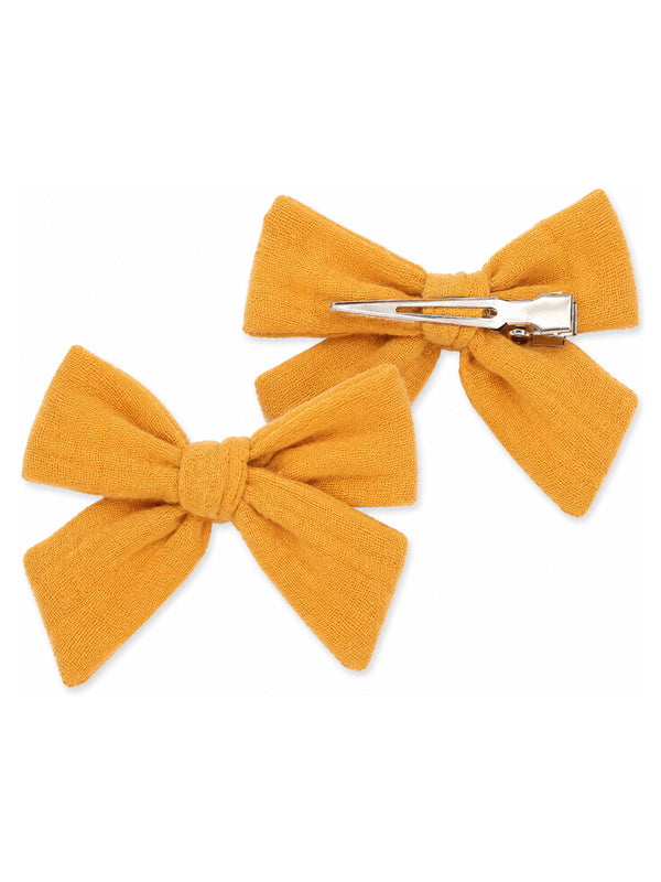 Two mustard yellow hair bows with clips. Ideal for kids' hairstyles and accessories.