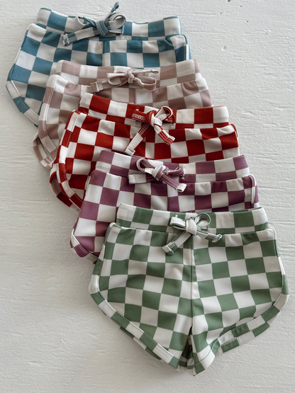Colorful checkered shorts stacked in rows, featuring blue, pink, red, purple, and green patterns.