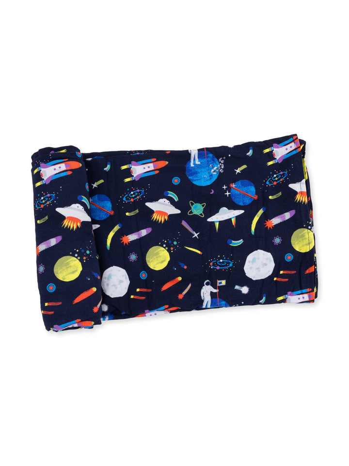 Space-themed blanket featuring colorful rockets, planets, and an astronaut on a dark background.