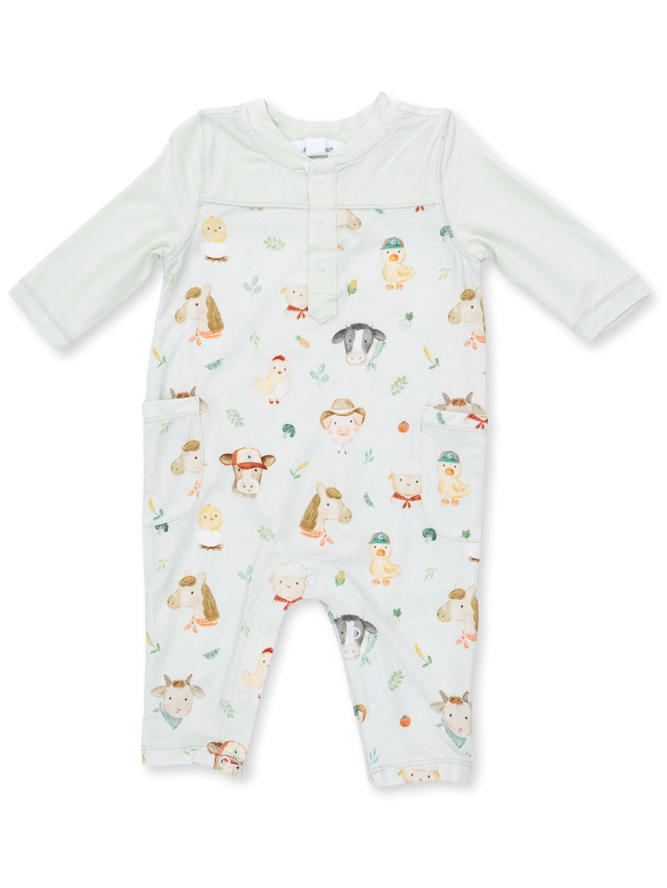 Light green baby romper with animal prints, including cows, ducks, and sheep, featuring button closure and pockets.