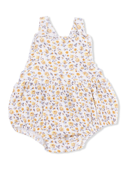 Floral infant romper with yellow and purple flowers on a white background, featuring ruffled straps and gathered bottom.