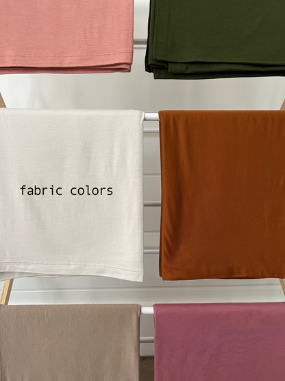 Assorted fabric swatches in various colors, including pink, green, white, orange, beige, and pink.